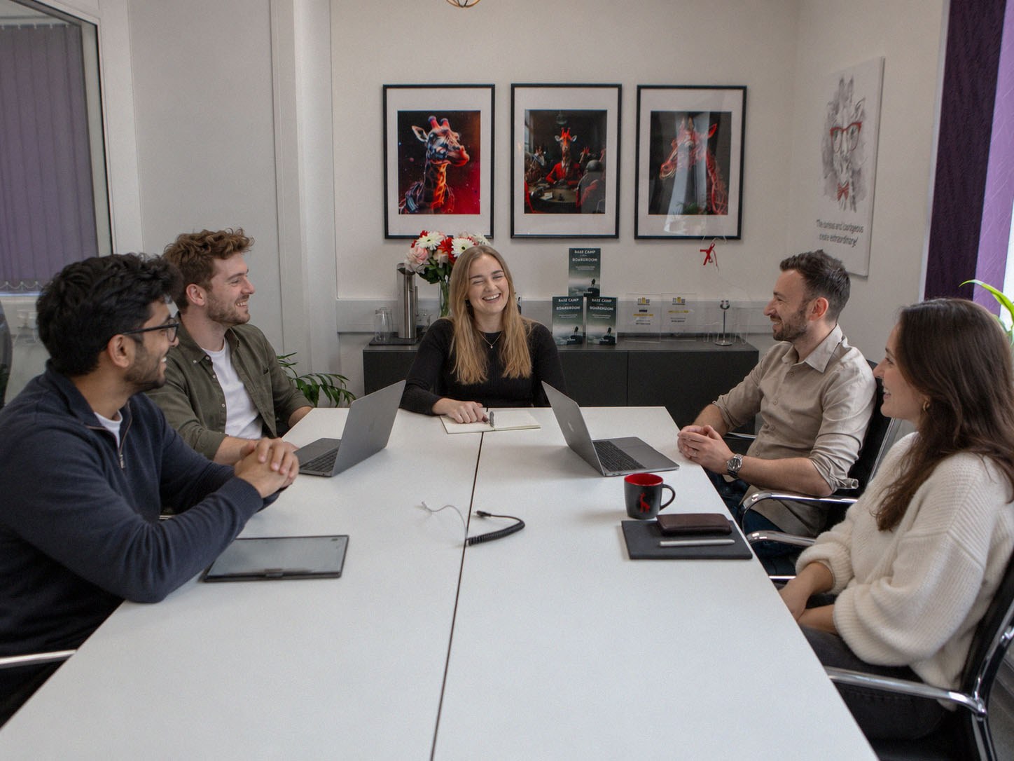 The Gather team sharing a laugh around their meeting table