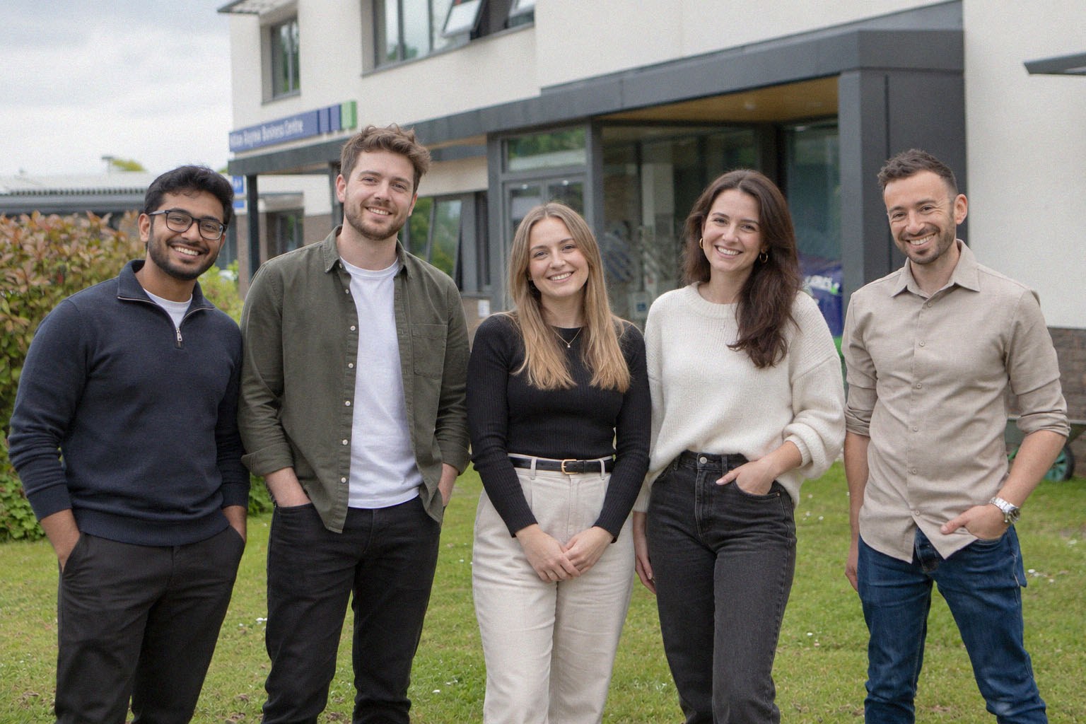The five-person Gather team standing together outside the office
