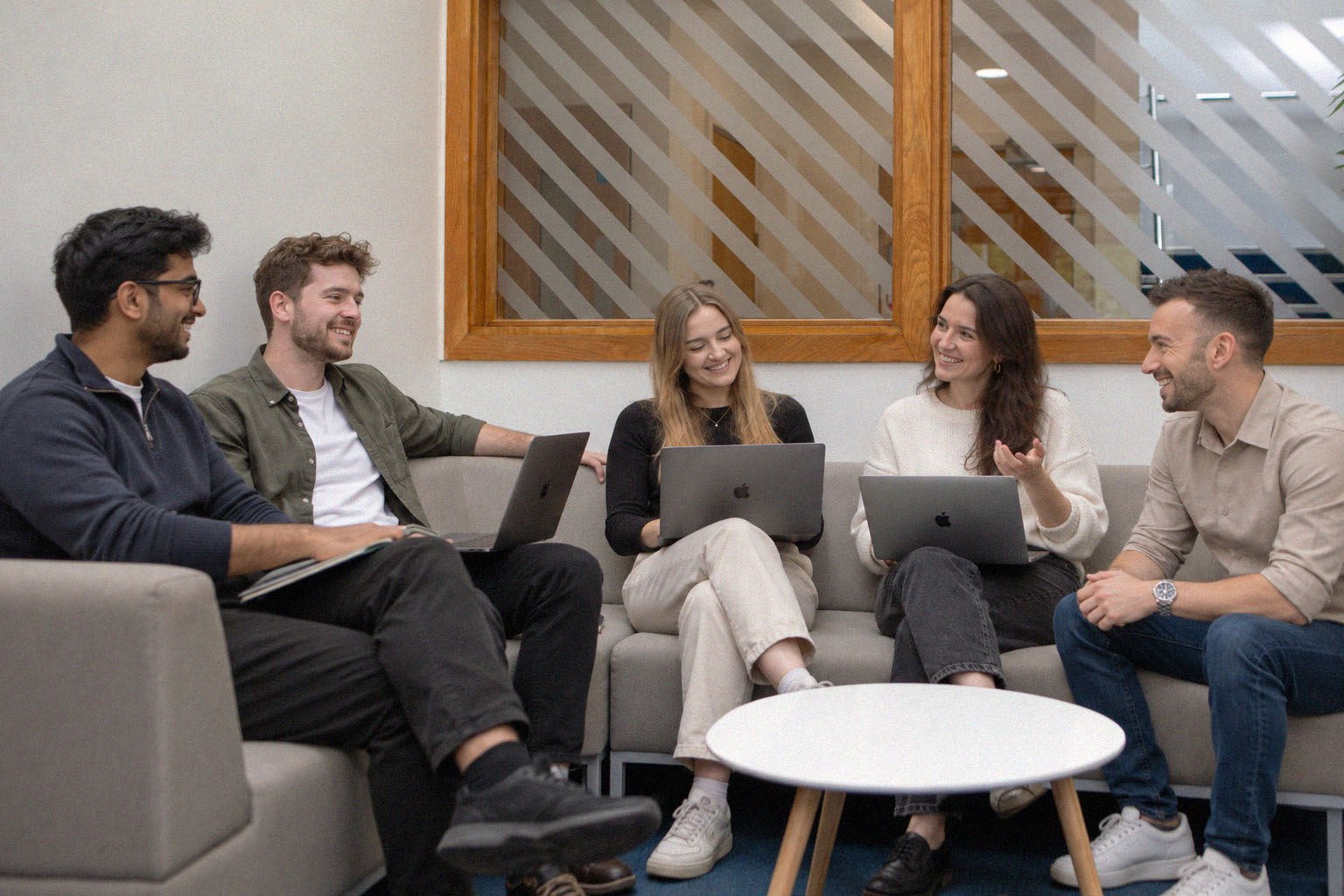 The Gather team chatting and working together on laptops